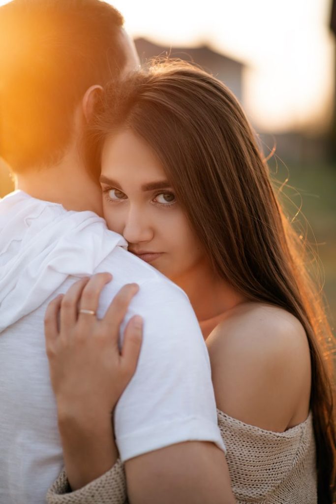 pexels-photo-18835154-18835154 Young couple embracing warmly at sunset, capturing a romantic moment outdoors.