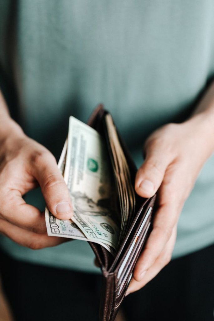 pexels-photo-4386433-4386433 From above of crop unrecognizable man in casual outfit holding wallet with banknotes getting dollars up