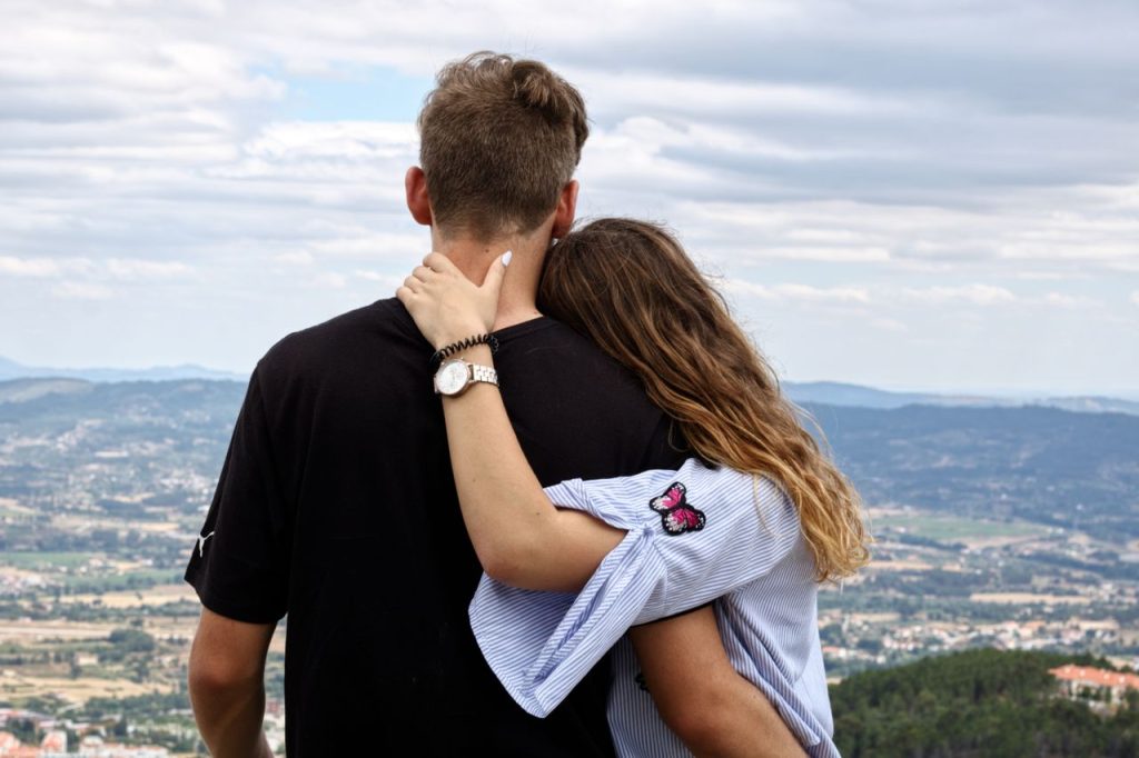 pexels-photo-5263706-5263706 A couple embraces while enjoying a scenic view from a hillside. Perfect for travel and romance themes.