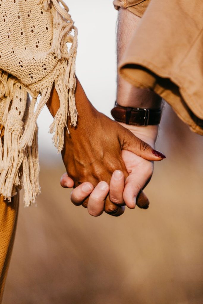 pexels-photo-9689774-9689774 A close-up shot of a diverse couple holding hands, symbolizing unity and love.